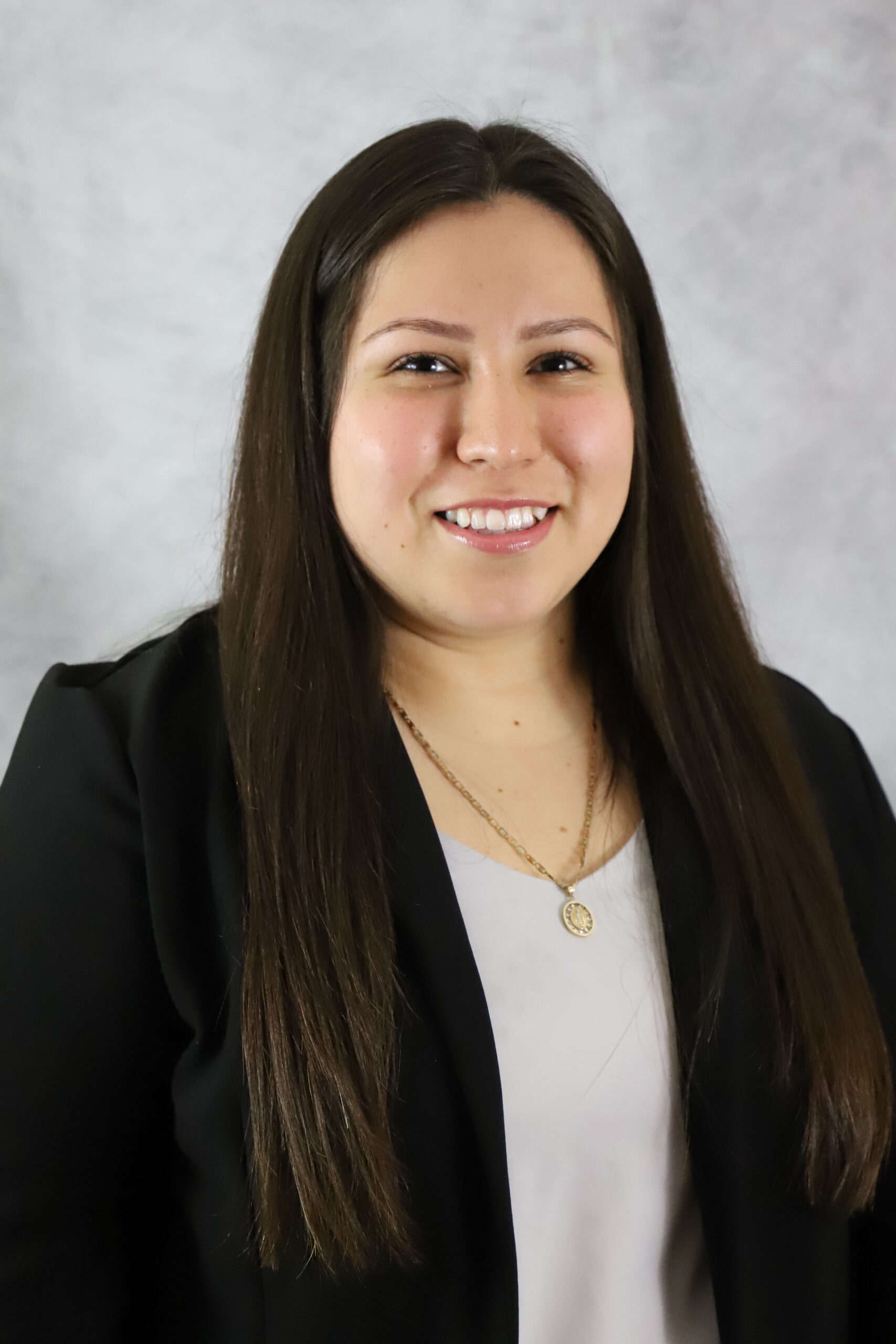 Portrait of Alondra Duran in a black top against a light gray background