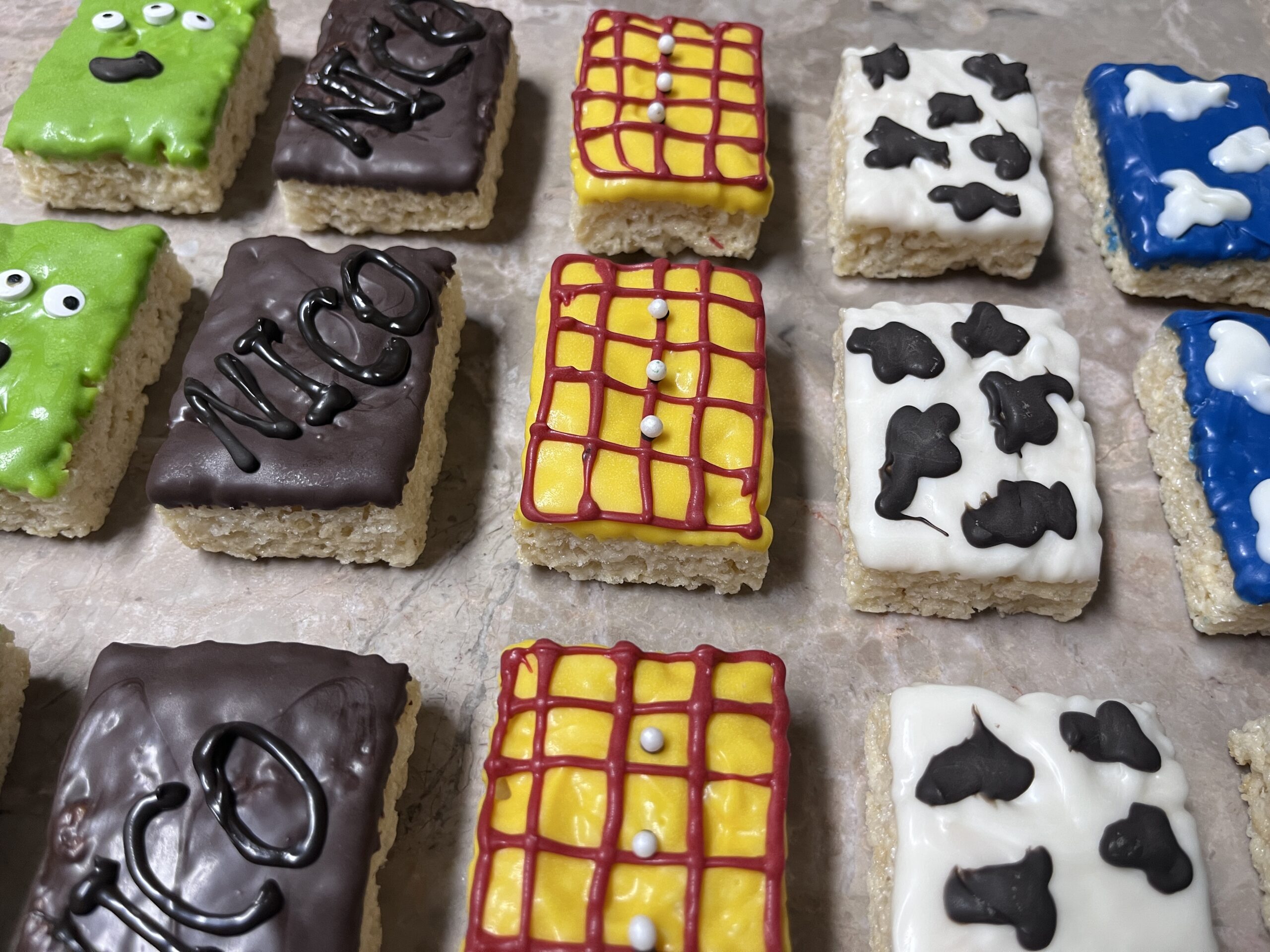 Decorated Rice Krispies treats arranged in rows with colorful icing designs