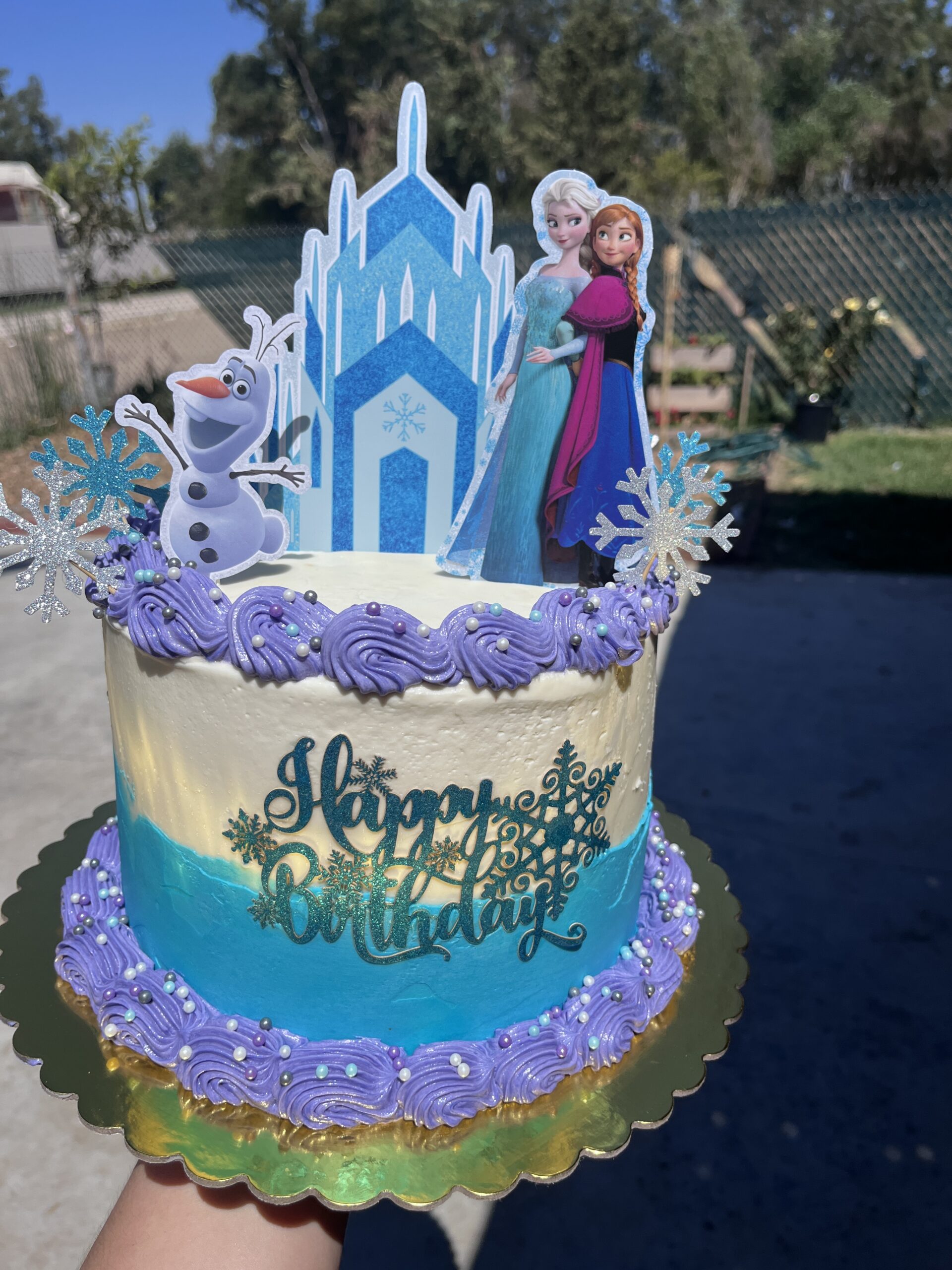 Blue and white decorated cake with purple swirls
